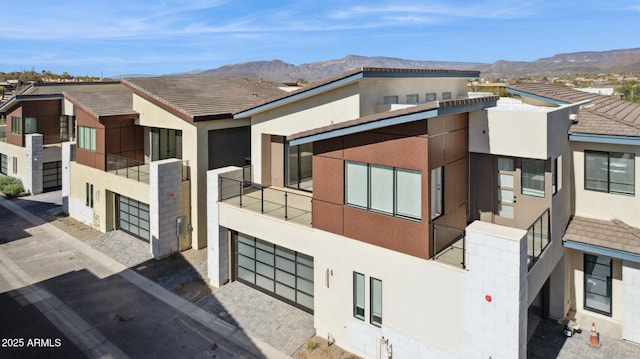 view of property featuring driveway, a mountain view, and a garage