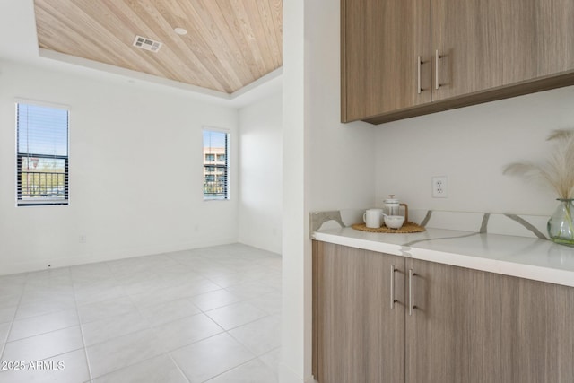 kitchen featuring light countertops, wooden ceiling, light tile patterned floors, visible vents, and modern cabinets