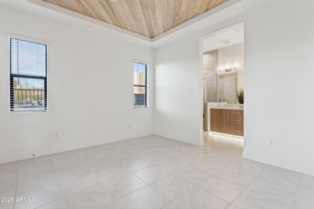 spare room with light tile patterned floors, wood ceiling, and baseboards