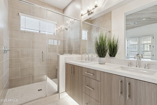 bathroom with a wealth of natural light, a sink, and a stall shower