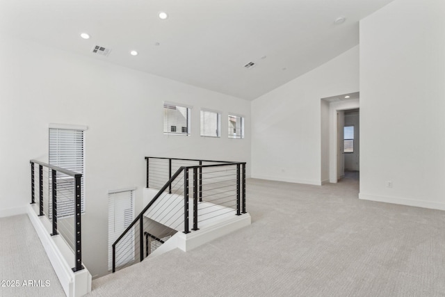interior space with carpet flooring, recessed lighting, visible vents, and lofted ceiling