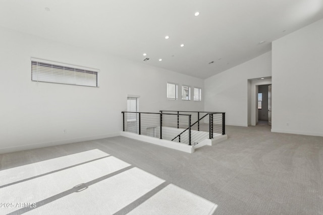 spare room with recessed lighting, baseboards, high vaulted ceiling, and light carpet