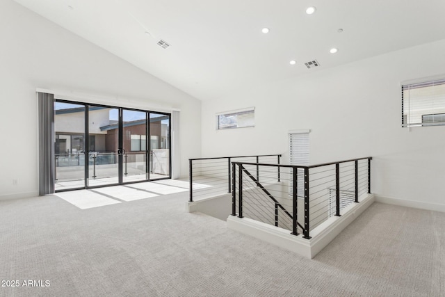 carpeted spare room featuring recessed lighting, baseboards, visible vents, and vaulted ceiling