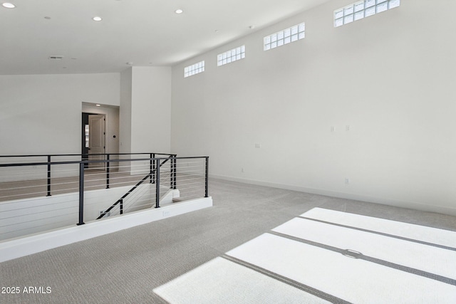 spare room featuring recessed lighting, carpet flooring, and baseboards