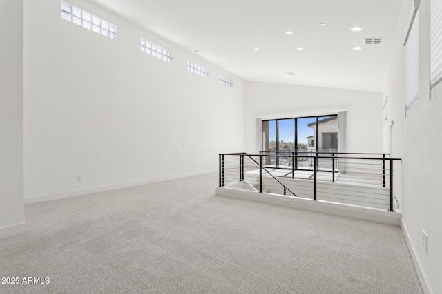 carpeted spare room with baseboards, recessed lighting, high vaulted ceiling, and visible vents