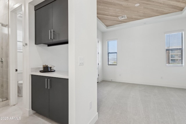 interior space featuring visible vents, gray cabinetry, wooden ceiling, baseboards, and light countertops