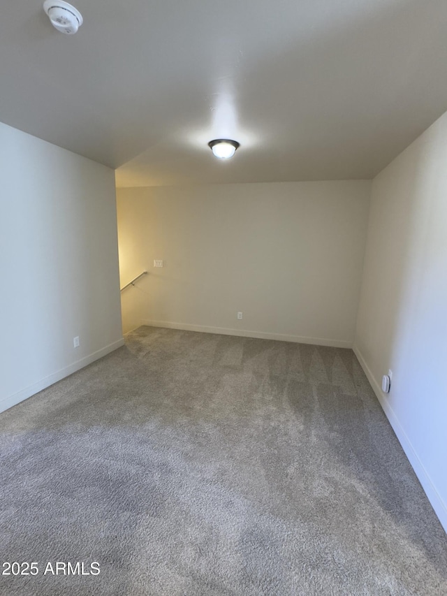 carpeted empty room featuring baseboards