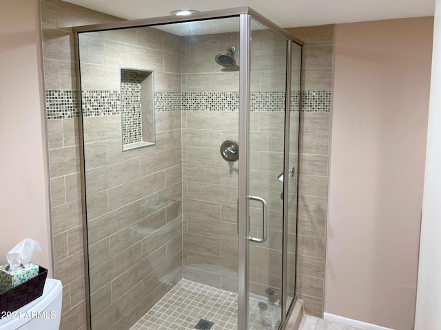 bathroom featuring walk in shower and toilet