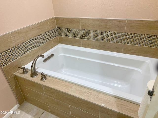 bathroom with tiled bath and tile patterned flooring