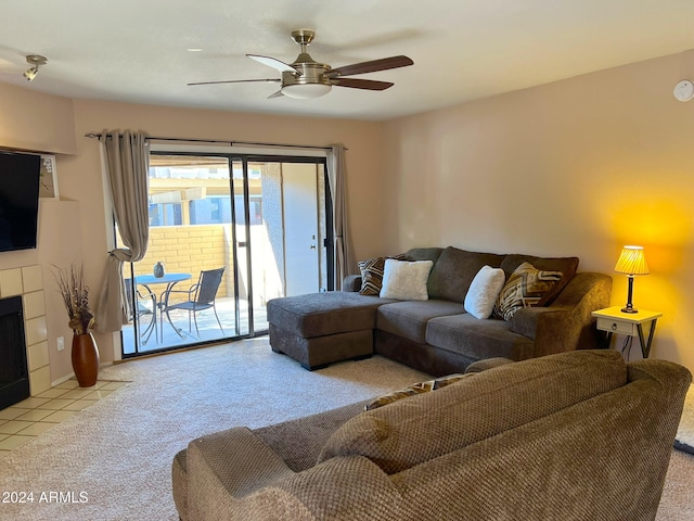 carpeted living room with ceiling fan and a fireplace