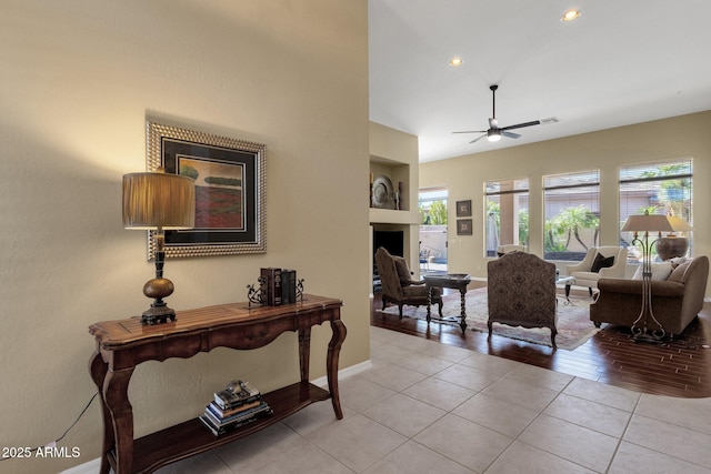 living room with light tile patterned flooring, a fireplace, baseboards, ceiling fan, and recessed lighting