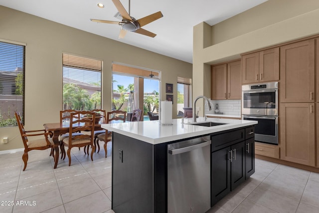 kitchen featuring a sink, appliances with stainless steel finishes, light tile patterned floors, and light countertops