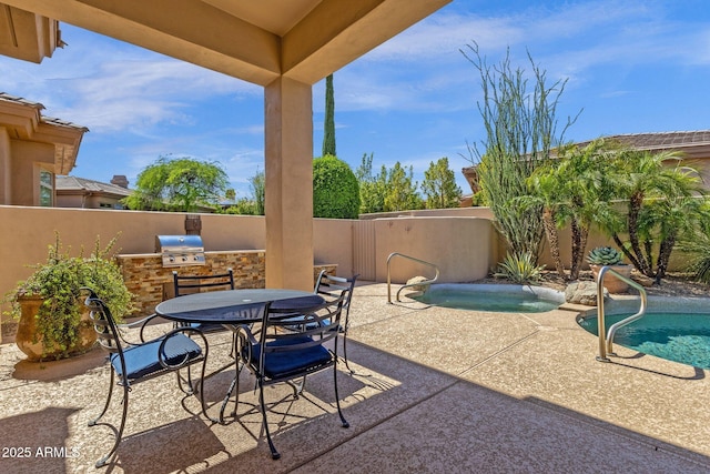 view of patio / terrace featuring grilling area, outdoor dining area, a fenced in pool, a fenced backyard, and an outdoor kitchen