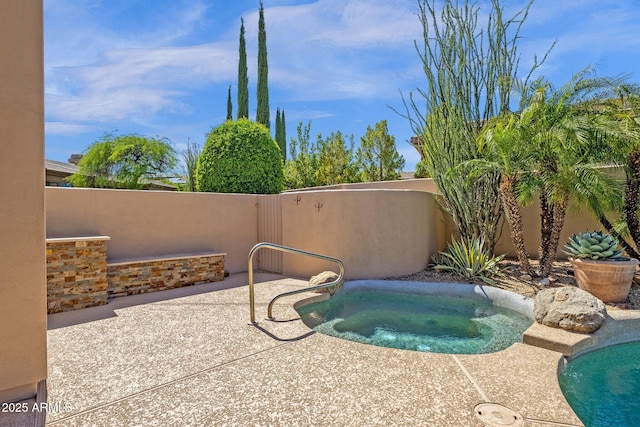 view of pool with a patio, an in ground hot tub, and fence