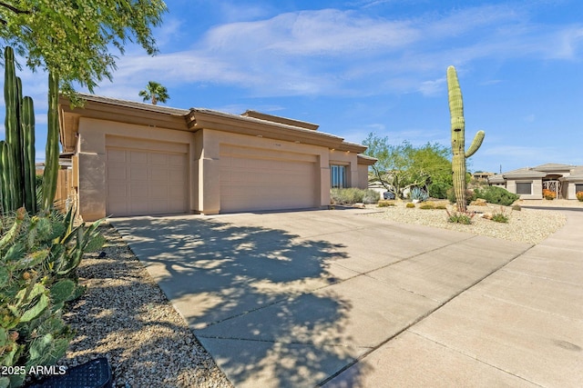 view of front of house featuring an attached garage, driveway, and stucco siding
