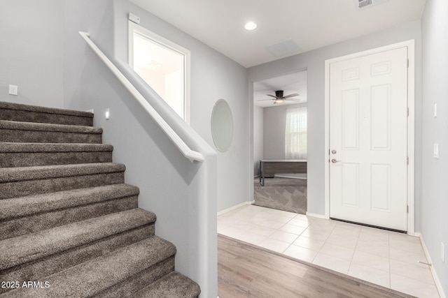 tiled foyer with ceiling fan