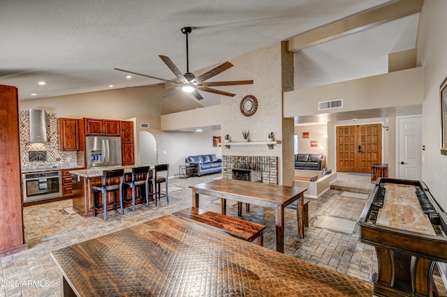 6520 E Peak View Rd, Cave Creek, AZ 85331 - living room with high vaulted ceiling, a ceiling fan, a brick fireplace, and recessed lighting