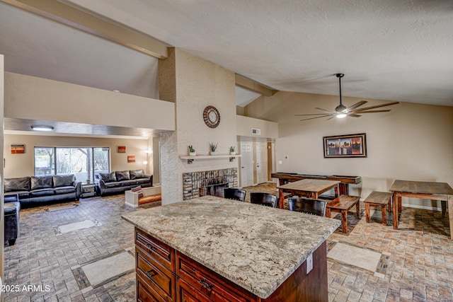 6520 E Peak View Rd, Cave Creek, AZ 85331 - kitchen with open floor plan, brick flooring, a ceiling fan, a brick fireplace, and light stone counters