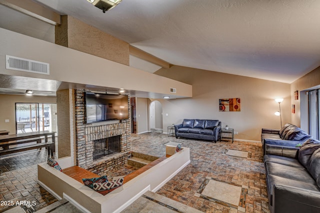 6520 E Peak View Rd, Cave Creek, AZ 85331 - living room with arched walkways, a fireplace, baseboards, high vaulted ceiling, and brick patterned flooring