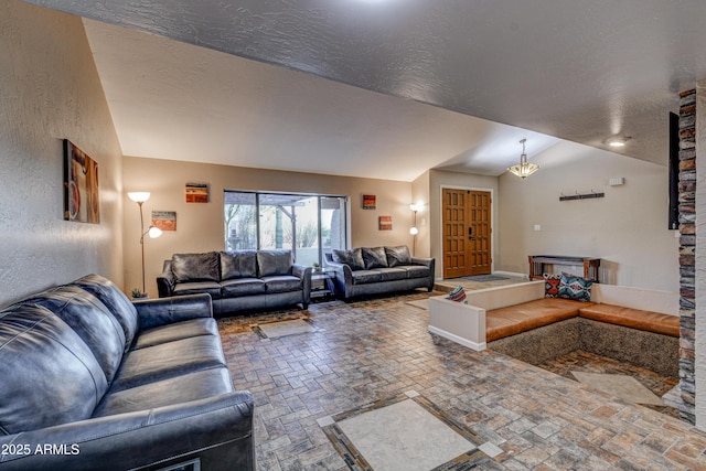 6520 E Peak View Rd, Cave Creek, AZ 85331 - living room with vaulted ceiling, brick flooring, a textured ceiling, and a textured wall