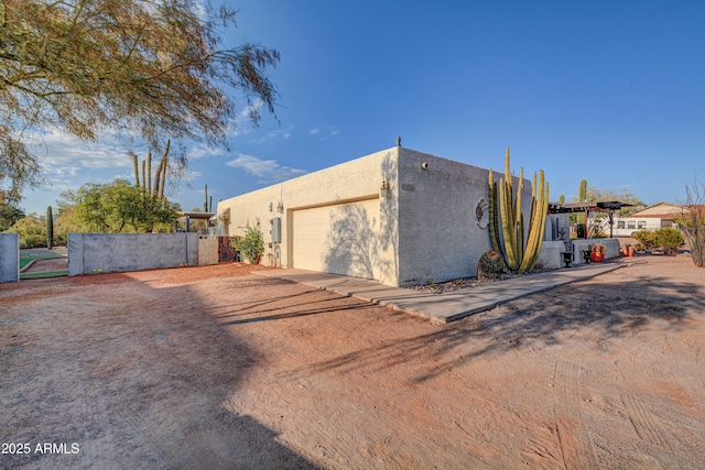 6520 E Peak View Rd, Cave Creek, AZ 85331 - view of side of home featuring stucco siding, a garage, fence, driveway, and a gate