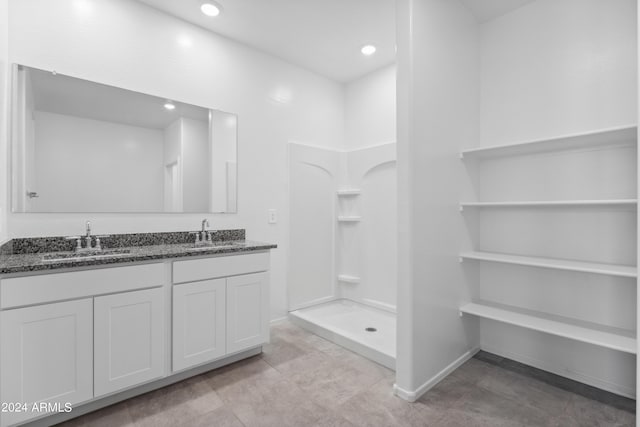 bathroom featuring a shower and vanity