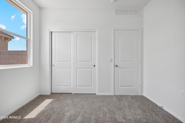 unfurnished bedroom featuring carpet floors and a closet