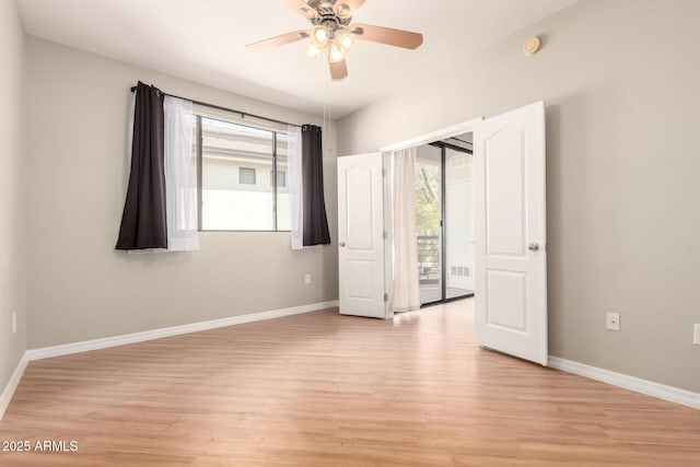 unfurnished room with a healthy amount of sunlight, light wood-style floors, and baseboards