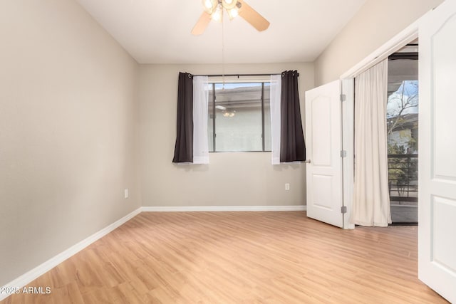 unfurnished room featuring light wood finished floors, plenty of natural light, ceiling fan, and baseboards