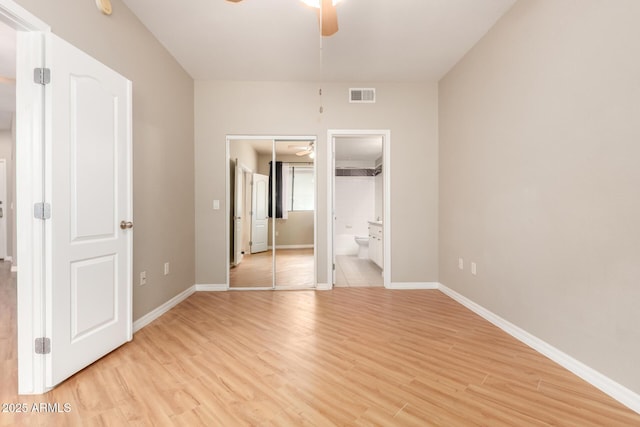 unfurnished bedroom with light wood-type flooring, visible vents, ensuite bath, baseboards, and ceiling fan