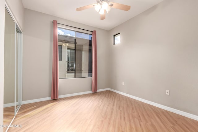 unfurnished bedroom featuring light wood-type flooring, baseboards, and ceiling fan