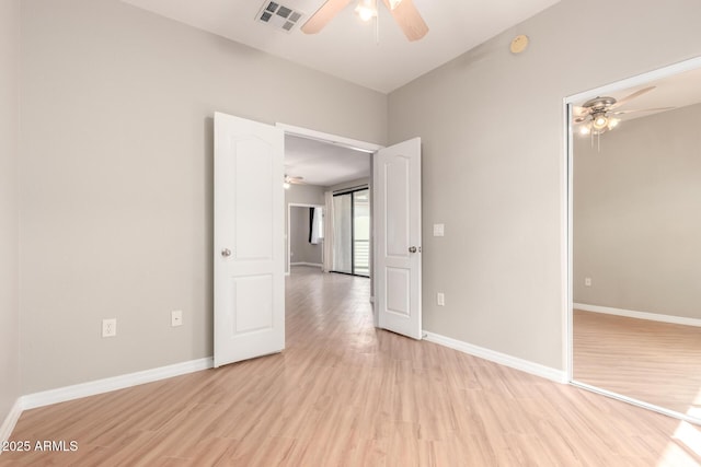 empty room featuring visible vents, baseboards, light wood-style flooring, and a ceiling fan