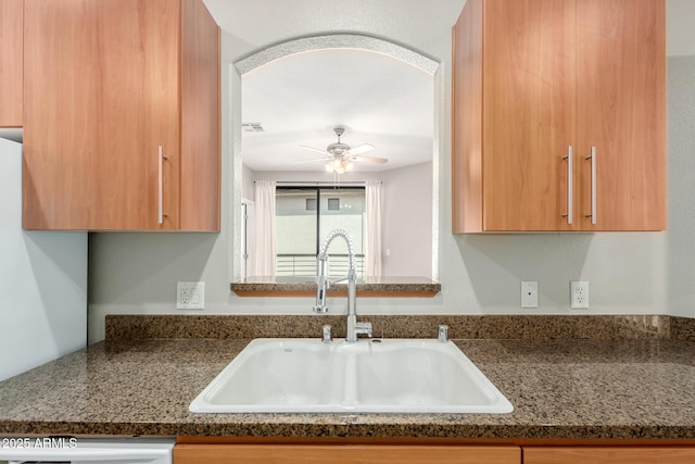 kitchen with visible vents, a sink, arched walkways, dishwashing machine, and ceiling fan