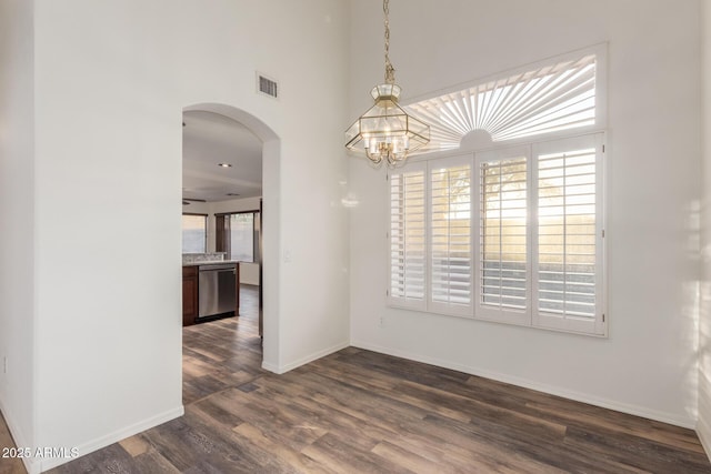 8450 S Stephanie Ln, Tempe, AZ 85284 - unfurnished dining area featuring arched walkways, dark wood finished floors, baseboards, and a chandelier