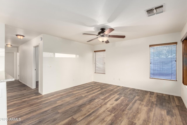 8450 S Stephanie Ln, Tempe, AZ 85284 - empty room featuring dark wood finished floors, a ceiling fan, and baseboards