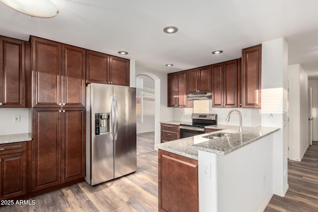 8450 S Stephanie Ln, Tempe, AZ 85284 - kitchen featuring appliances with stainless steel finishes, a sink, under cabinet range hood, light wood-style floors, and arched walkways