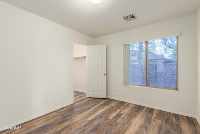 8450 S Stephanie Ln, Tempe, AZ 85284 - unfurnished bedroom with wood finished floors, baseboards, a walk in closet, and a closet