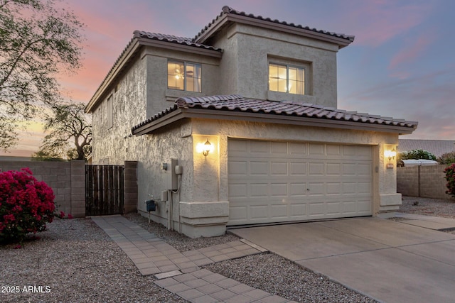 8450 S Stephanie Ln, Tempe, AZ 85284 - mediterranean / spanish-style home with driveway, stucco siding, an attached garage, and a tile roof