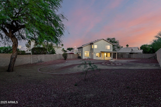 8450 S Stephanie Ln, Tempe, AZ 85284 - back of property at dusk featuring a fenced backyard, a patio area, and stucco siding