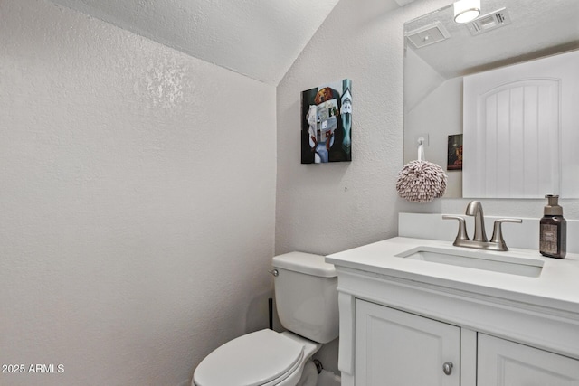1914 S Brooks Cir, Mesa, AZ 85202 - half bathroom with vanity, a textured wall, lofted ceiling, toilet, and a textured ceiling