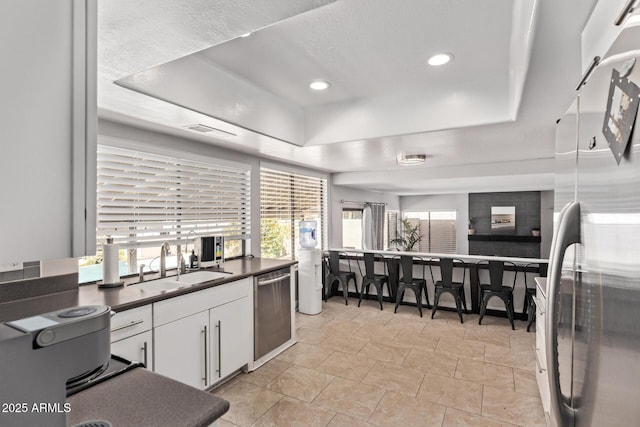 1914 S Brooks Cir, Mesa, AZ 85202 - kitchen with stainless steel appliances, a tray ceiling, dark countertops, a sink, and recessed lighting