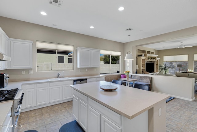 kitchen featuring sink, white cabinetry, a kitchen island, pendant lighting, and stainless steel appliances