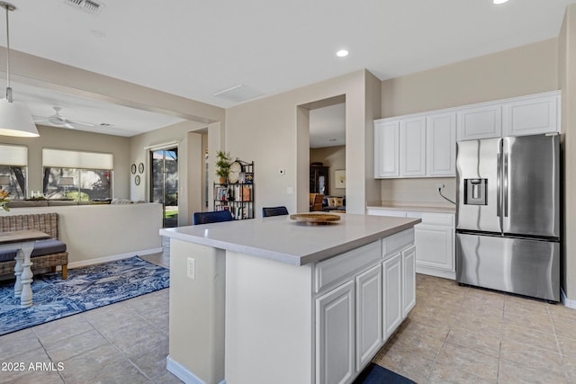 kitchen with pendant lighting, ceiling fan, white cabinetry, a kitchen island, and stainless steel fridge with ice dispenser