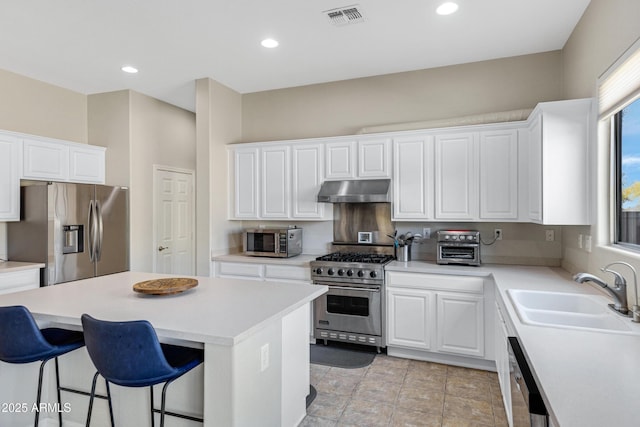 kitchen featuring appliances with stainless steel finishes, a center island, sink, and white cabinets