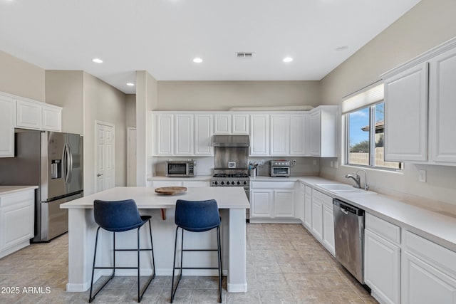 kitchen featuring white cabinetry, appliances with stainless steel finishes, a center island, and sink