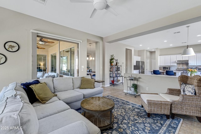 living room featuring light tile patterned floors and ceiling fan with notable chandelier