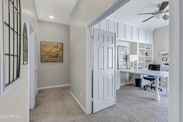 carpeted office space featuring ceiling fan