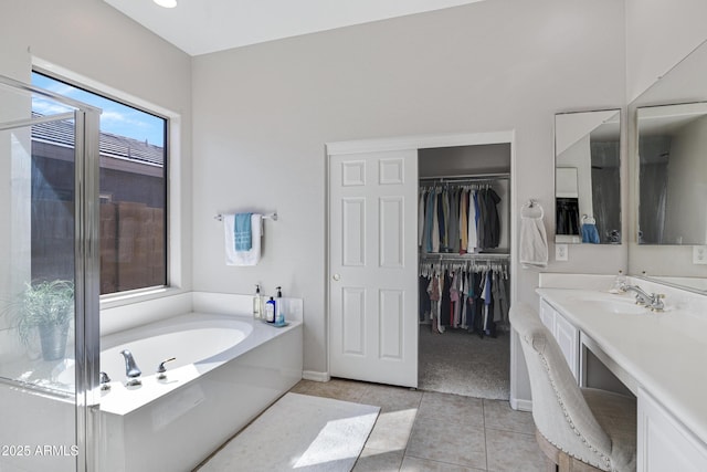 bathroom with tile patterned flooring, vanity, and a washtub