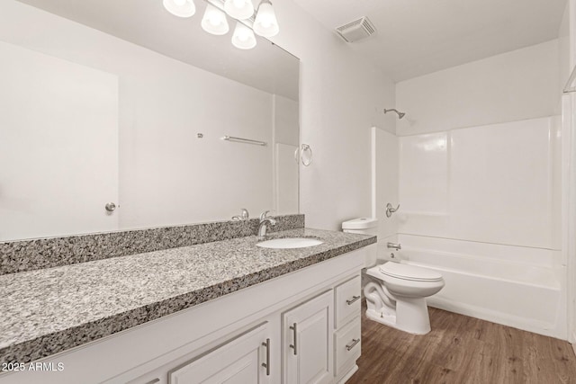 full bathroom with wood-type flooring, toilet,  shower combination, and vanity