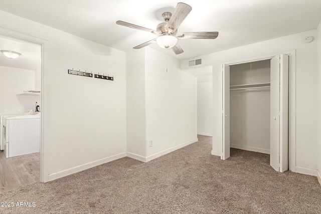 unfurnished bedroom with ceiling fan, light colored carpet, separate washer and dryer, and a closet